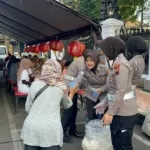 Anggoyta Polresta Pati melayani warga yang ingin menikmati makan gratis di Alun - Alun Simpang Lima Pati.