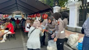 Anggoyta Polresta Pati melayani warga yang ingin menikmati makan gratis di Alun - Alun Simpang Lima Pati.