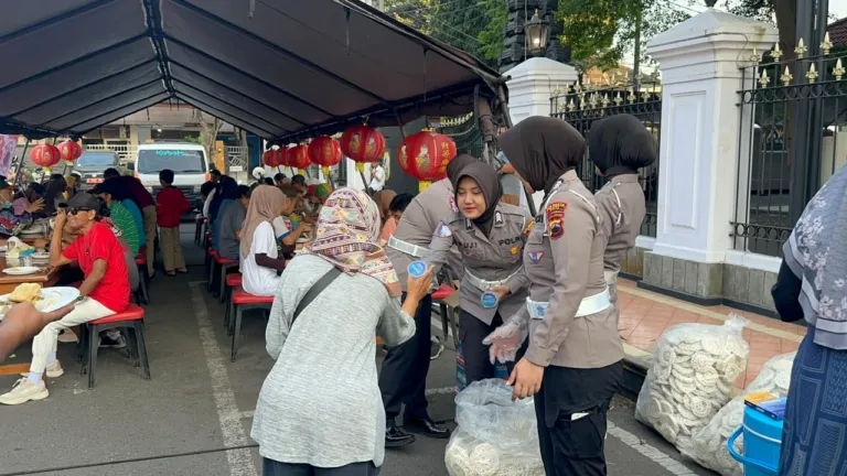 Anggoyta Polresta Pati melayani warga yang ingin menikmati makan gratis di Alun - Alun Simpang Lima Pati.